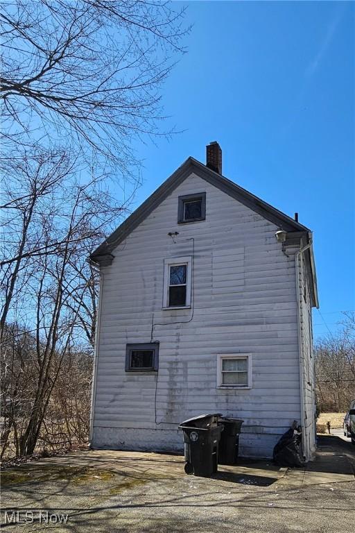 view of side of home featuring a chimney