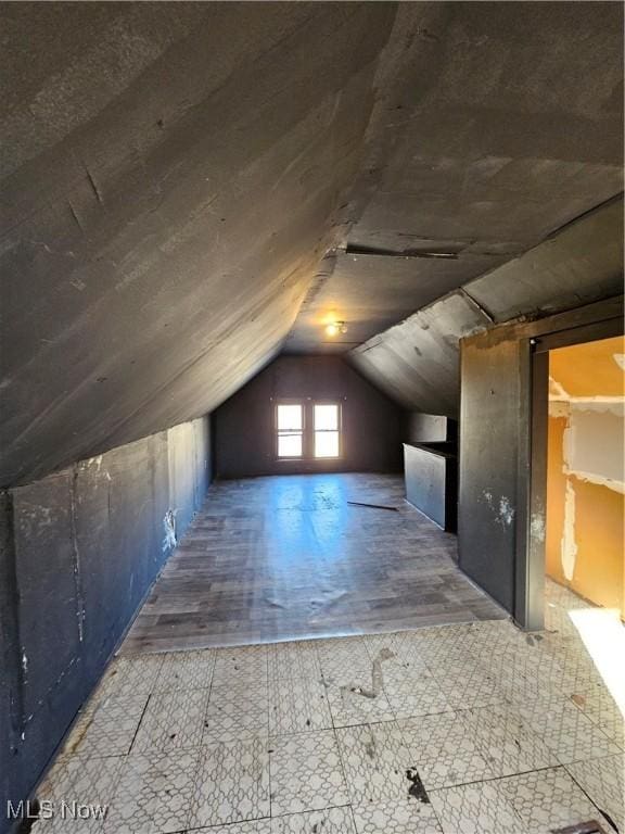 bonus room with wood finished floors and vaulted ceiling