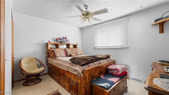 bedroom featuring light carpet, visible vents, and a textured ceiling