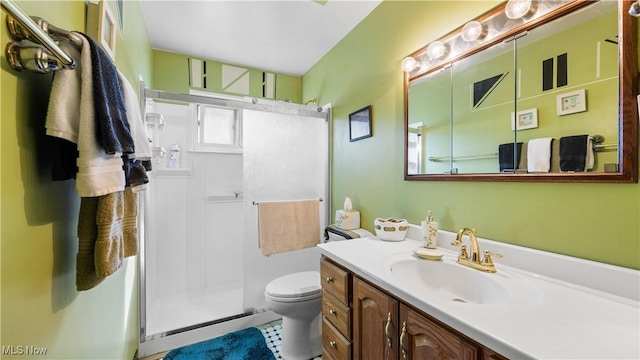 full bathroom with vanity, a shower stall, and toilet