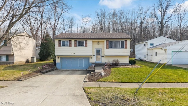 raised ranch featuring a garage, driveway, a front lawn, and entry steps