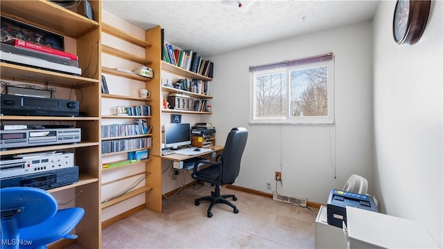 office area featuring baseboards, light colored carpet, and a textured ceiling