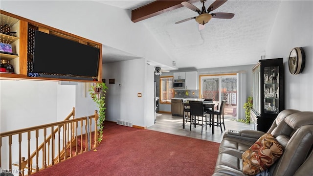 living area with visible vents, light carpet, a ceiling fan, a textured ceiling, and vaulted ceiling with beams