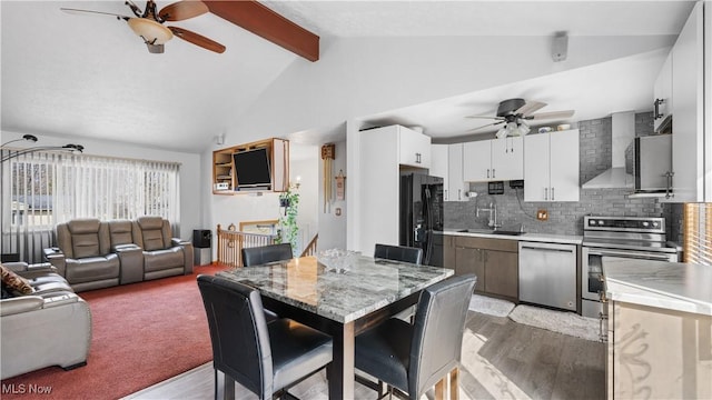 dining space featuring lofted ceiling with beams, light wood-style floors, and ceiling fan