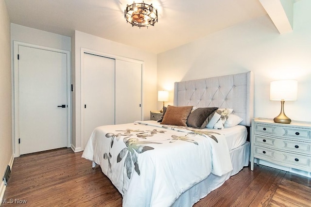 bedroom with dark wood-style flooring and a closet