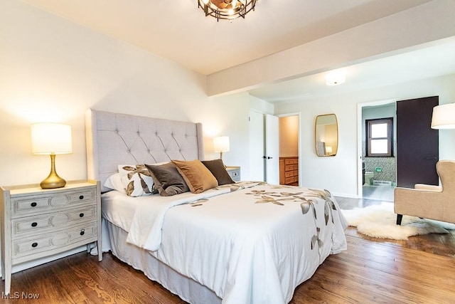 bedroom featuring beam ceiling, ensuite bath, and dark wood-type flooring