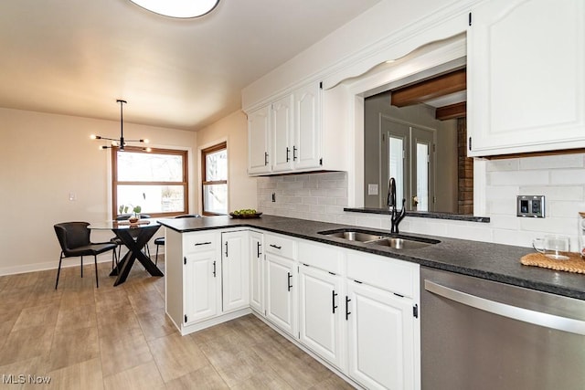 kitchen featuring a sink, tasteful backsplash, white cabinets, baseboards, and dishwasher