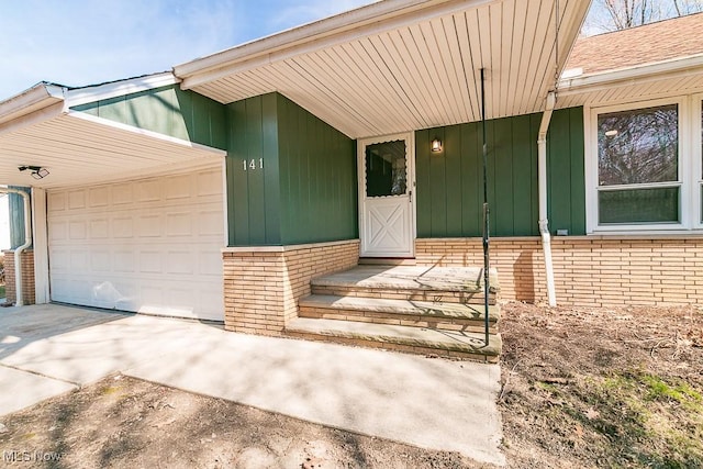 entrance to property with brick siding, concrete driveway, and a garage