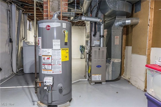 utility room with heating unit, gas water heater, and washer / clothes dryer