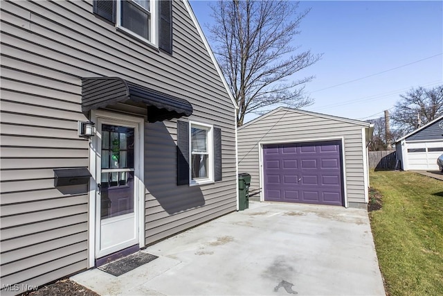 entrance to property featuring concrete driveway, a yard, fence, and a garage