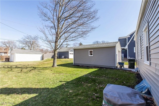 view of yard featuring an outbuilding and fence