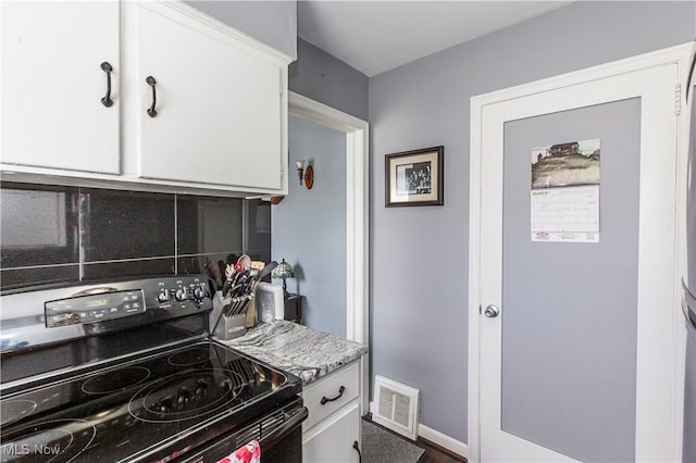 kitchen with visible vents, light countertops, decorative backsplash, white cabinets, and black electric range oven