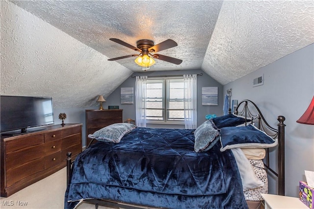 bedroom with visible vents, carpet floors, ceiling fan, vaulted ceiling, and a textured ceiling