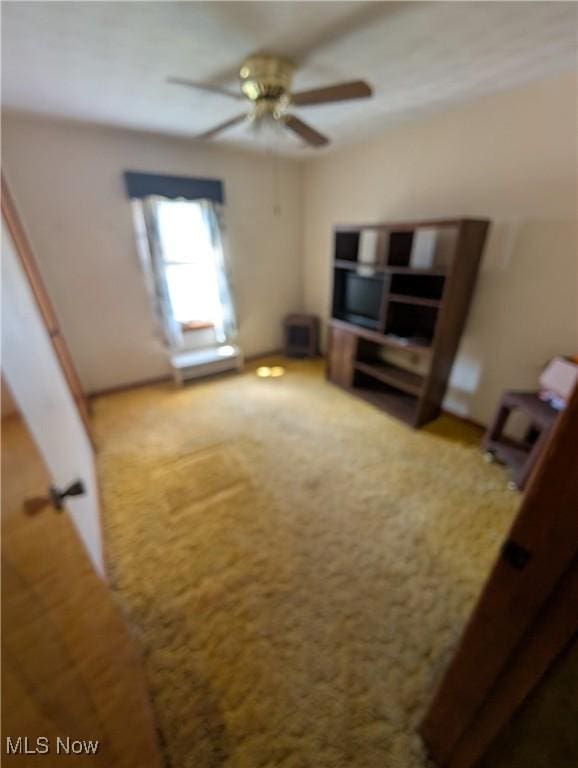 unfurnished living room with ceiling fan and carpet floors