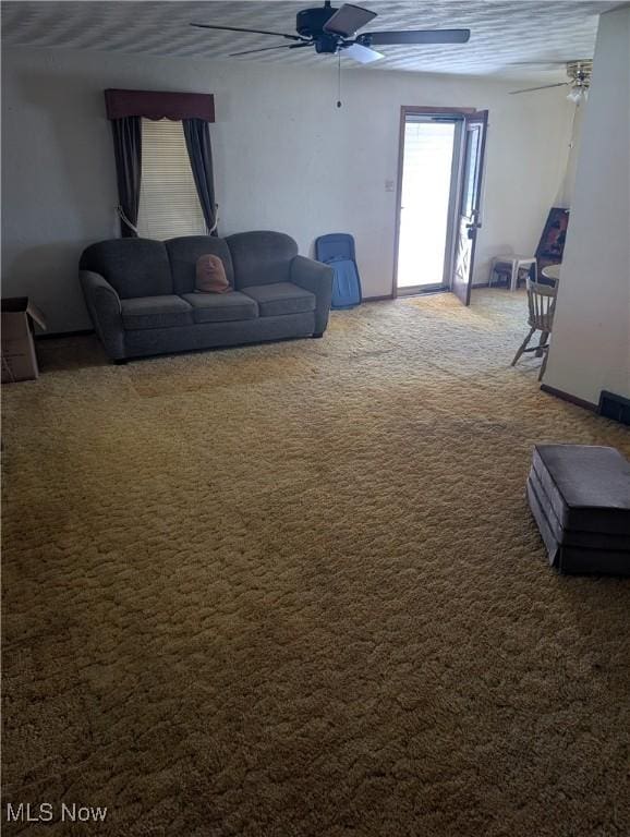 carpeted living room with a ceiling fan and baseboards