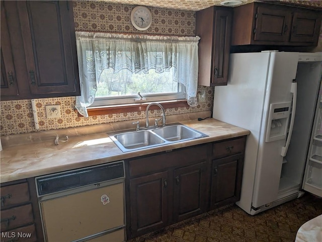 kitchen featuring white fridge with ice dispenser, dishwashing machine, light countertops, and a sink