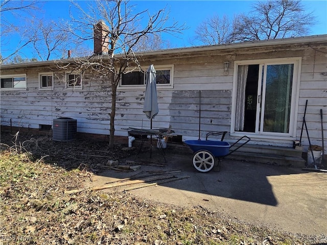 back of property with cooling unit and a chimney