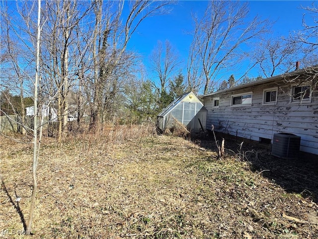 view of yard featuring an exterior structure, an outbuilding, and central AC