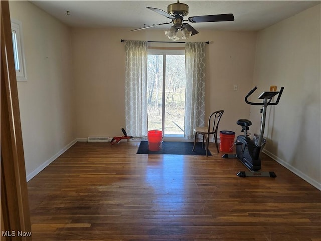 workout area with baseboards, wood finished floors, visible vents, and ceiling fan