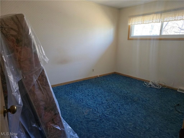 spare room with baseboards and carpet