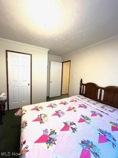 bedroom with a textured ceiling and ornamental molding