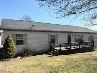 back of house featuring a lawn and a wooden deck