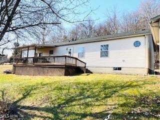 rear view of property featuring a lawn and a deck