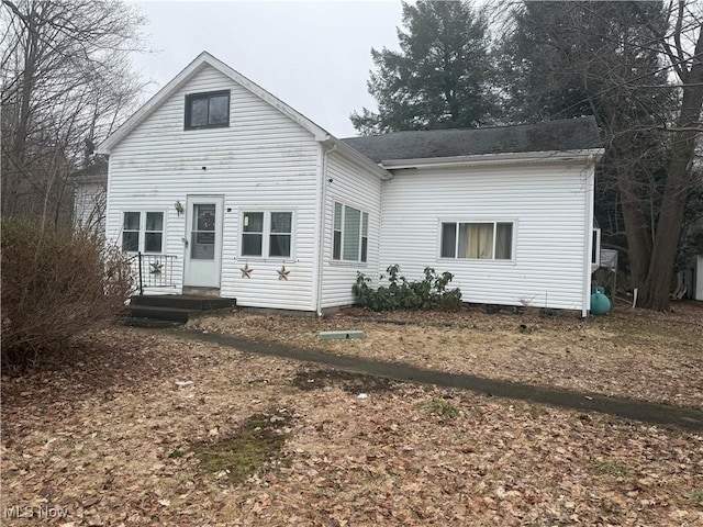 rear view of house with a shingled roof