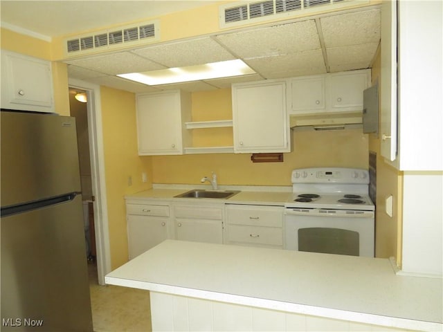 kitchen featuring visible vents, under cabinet range hood, freestanding refrigerator, electric stove, and a sink