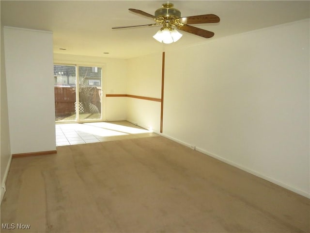 unfurnished room with a ceiling fan and baseboards