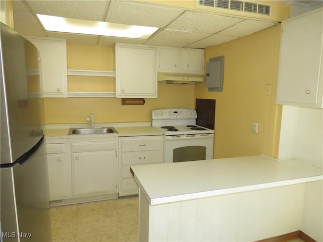 kitchen with white range with electric cooktop, under cabinet range hood, electric panel, freestanding refrigerator, and a sink