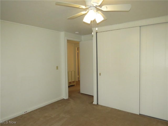 unfurnished bedroom with a closet, carpet floors, and ceiling fan