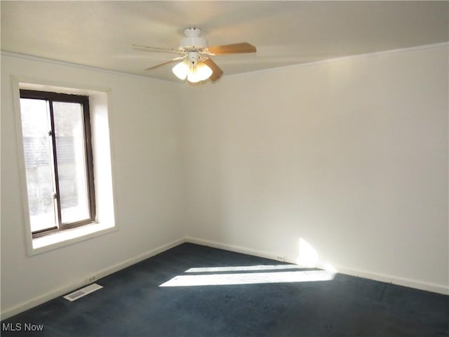 empty room with a ceiling fan, visible vents, and baseboards