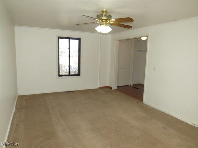 unfurnished room with carpet flooring, baseboards, and a ceiling fan