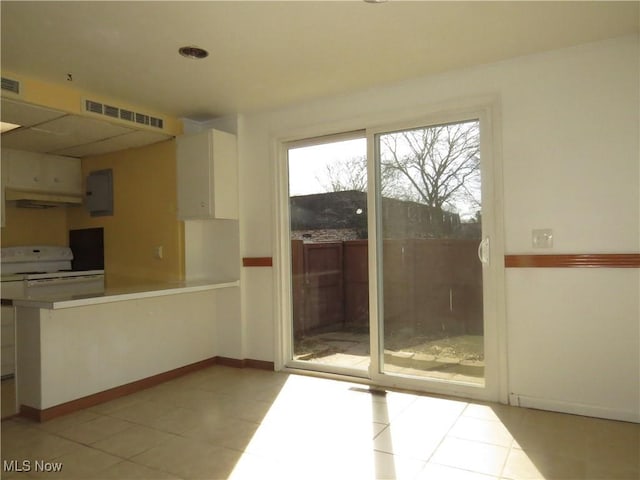 interior space featuring white electric stove, visible vents, baseboards, and white cabinetry