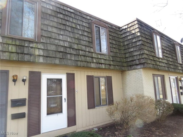 view of property exterior with mansard roof