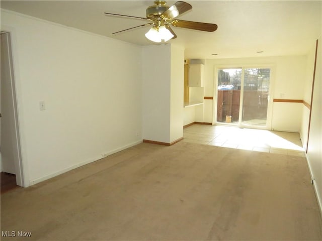 unfurnished room featuring light carpet, baseboards, and a ceiling fan