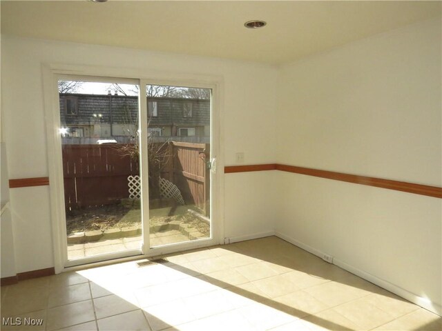 unfurnished room with tile patterned floors and baseboards