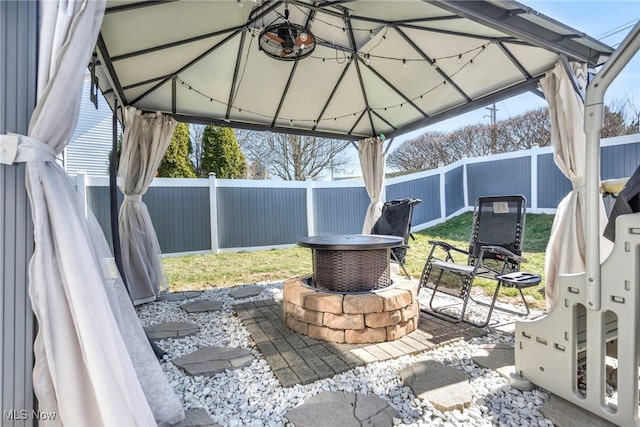 view of patio with a gazebo, a fire pit, and a fenced backyard