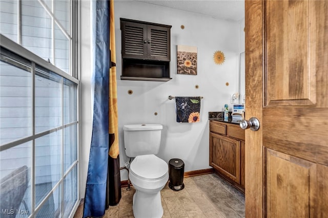 bathroom featuring a textured ceiling, toilet, vanity, and baseboards