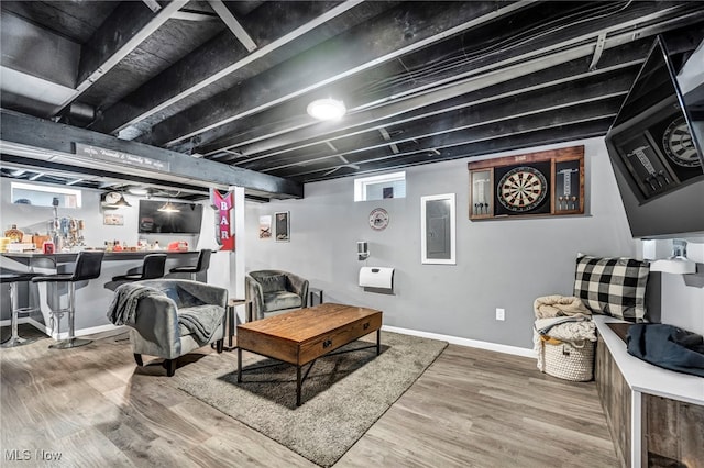 living area with bar, wood finished floors, and baseboards