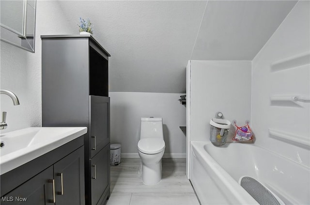 full bath with toilet, vanity, baseboards, and vaulted ceiling