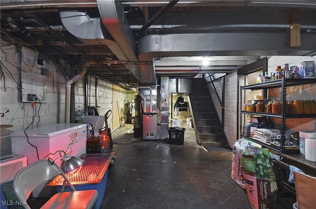 unfinished basement with stairway and heating unit