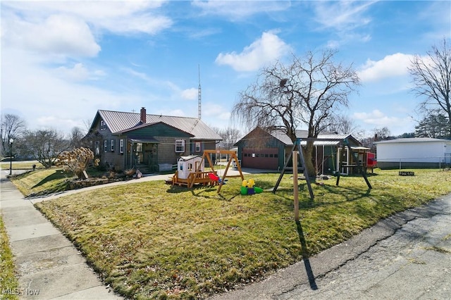 exterior space with metal roof, a chimney, a front lawn, and a playground