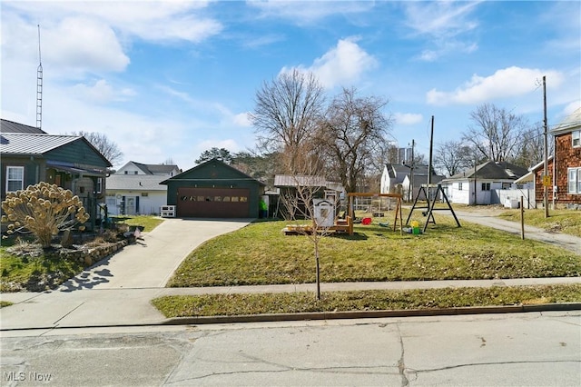 view of front of home with a detached garage, a front yard, a residential view, and an outdoor structure