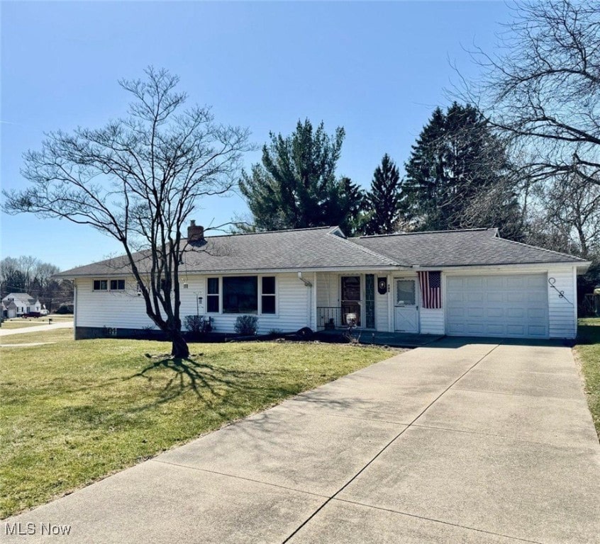 single story home with a front lawn, a porch, concrete driveway, a chimney, and a garage