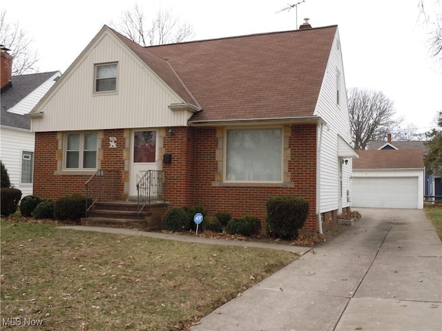 view of front facade featuring brick siding, a shingled roof, an outdoor structure, and a front yard