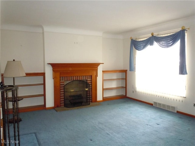 unfurnished living room featuring a brick fireplace, baseboards, visible vents, and carpet floors