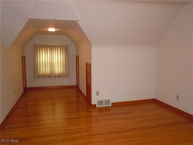 bonus room featuring visible vents, baseboards, lofted ceiling, and wood finished floors