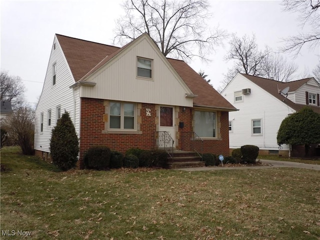 bungalow-style house featuring a front yard, brick siding, and roof with shingles